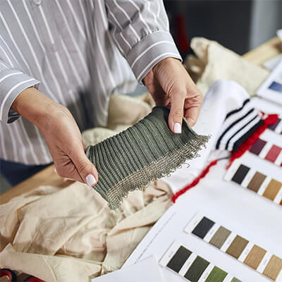 woman holding knitwear sample with thread