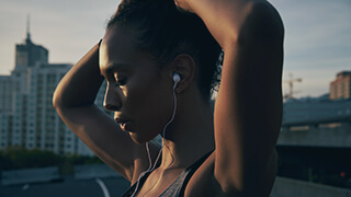 woman running city skyline headphones closeup